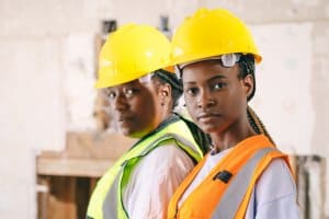 Mulheres engenheiras com expressão séria, usando capacete amarelo. Ilustração do texto sobre franquias de reformas e reparo.
