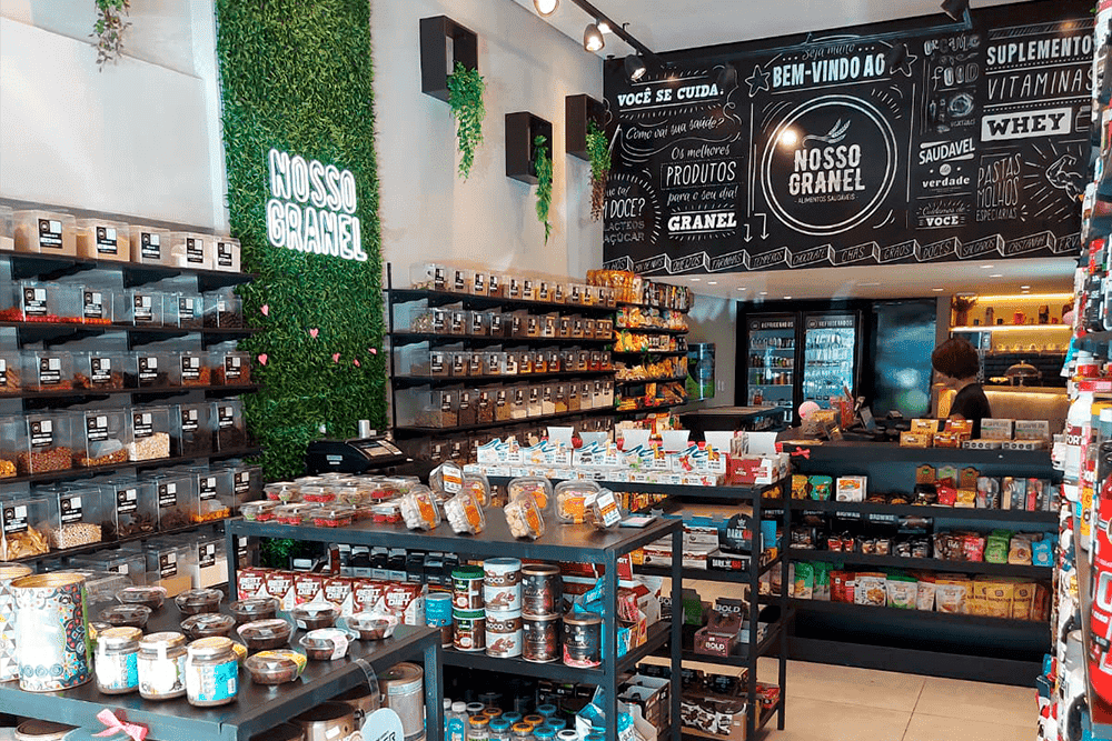 As 128 melhores franquias baratas em 2026 - veja a lista Interior da loja Nosso Granel, com prateleiras.