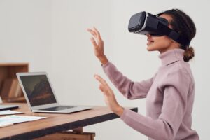 Mulher sorridente, usando óculos de realidade virtual preto. Ilustração do texto sobre negócios do futuro.