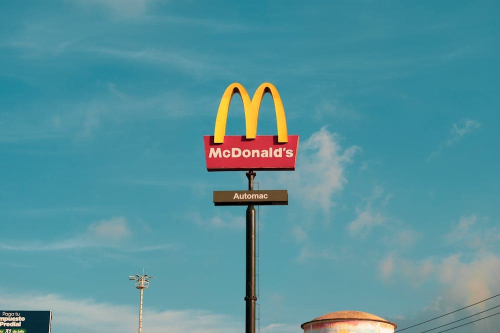 Arcos dourados do Mc Donalds se destacando no céu azul. Ilustração do texto sobre franquias mais caras no Brasil.