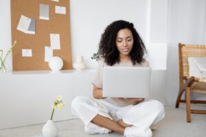 Mulher sorridente, segurando o notebook cinza. Ilustração do texto sobre setores para abrir empresa.