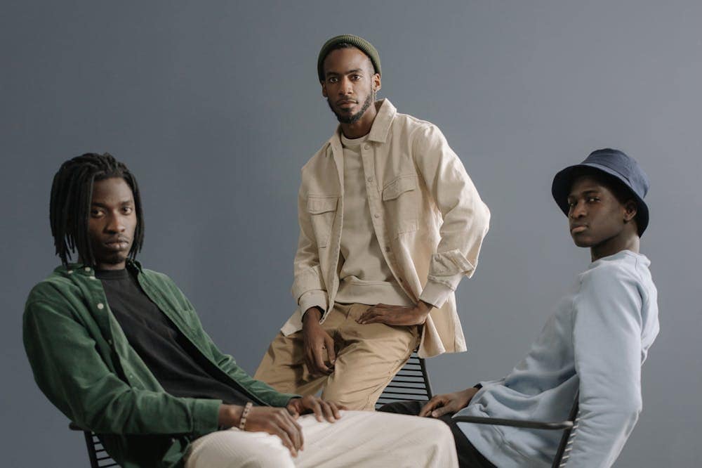 Homens sérios, bem-vestidos, posando em frente a fundo cinza. Ilustração do texto sobre roupa masculina.