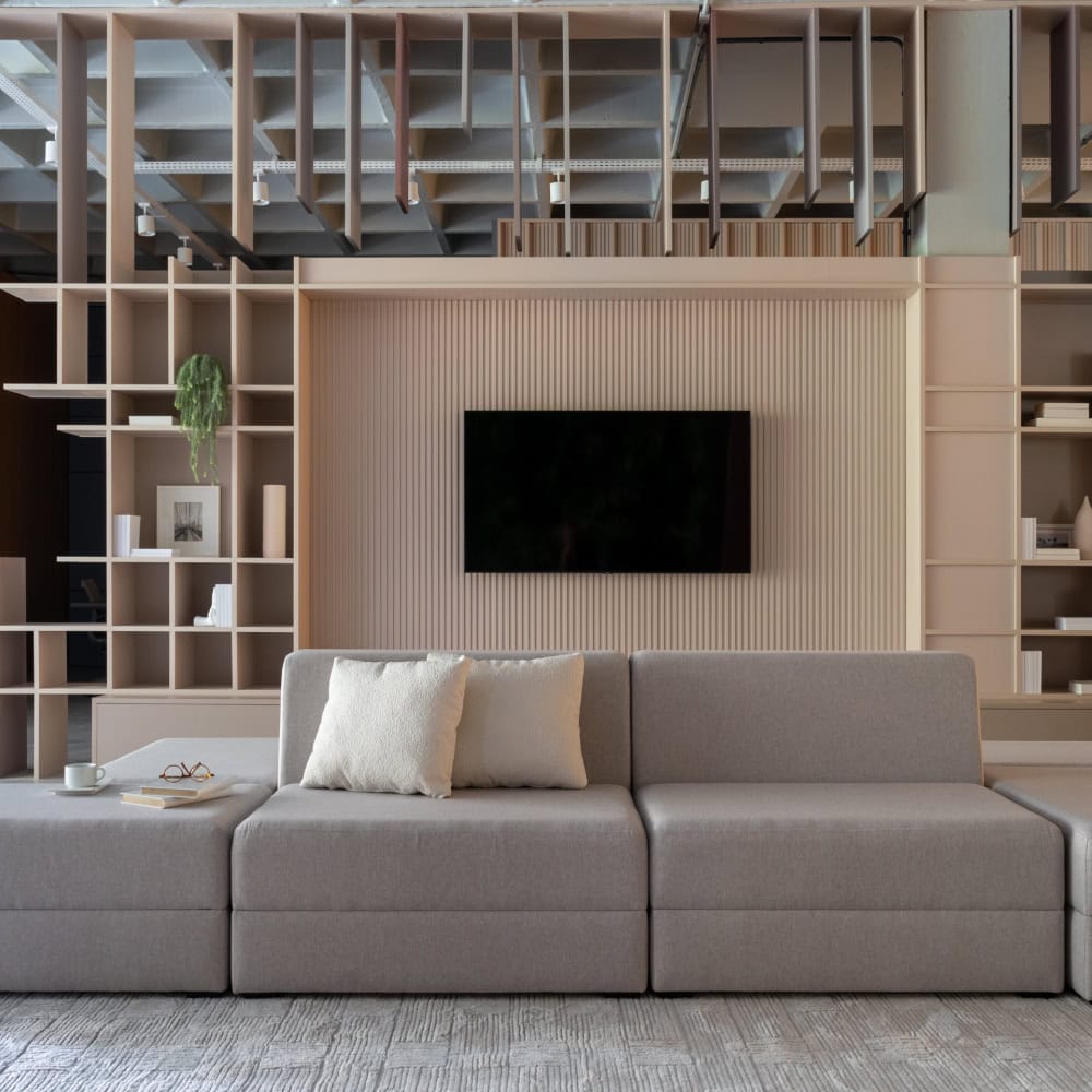 As 128 melhores franquias baratas em 2026 - veja a lista Exemplo de móveis planejados pela Italínea (estante em uma sala ampla com sofá e televisão).