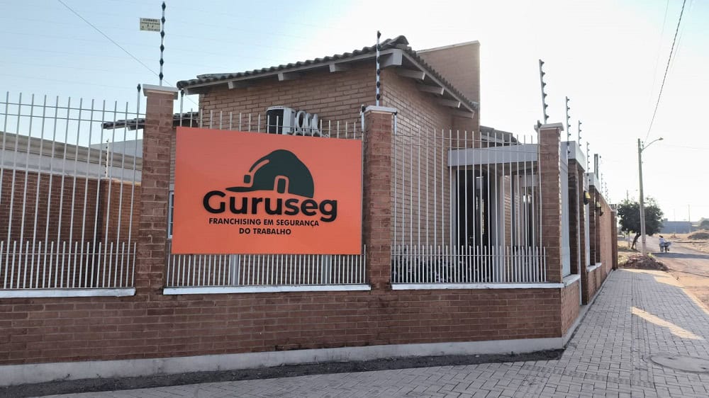 As 128 melhores franquias baratas em 2026 - veja a lista Fachada de unidade da franquia Guruseg, com placa laranja e a logo da rede impressa em preto.