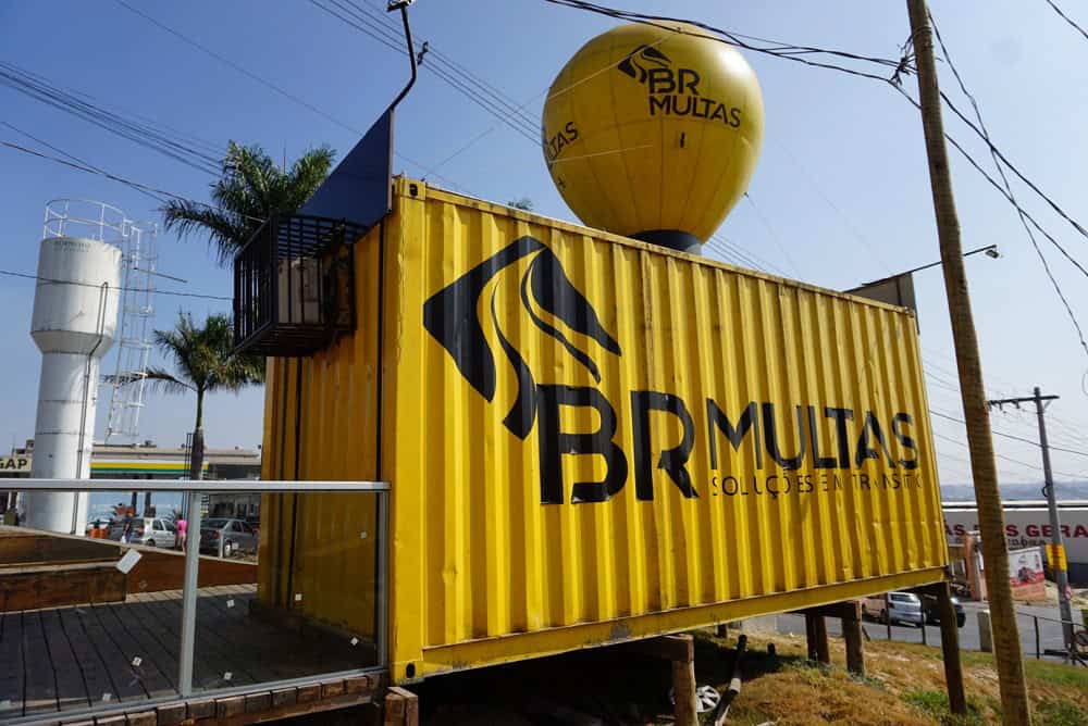 As 128 melhores franquias baratas em 2026 - veja a lista Unidade de franquia BR Multas, modelo container. A cor amarela predomina na imagem, pois é a cor oficial da marca.