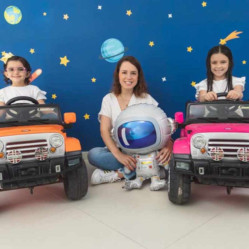 Isabel Tunas, fundadora da Facilitoy, com crianças ao redor sentados em carros infantis.