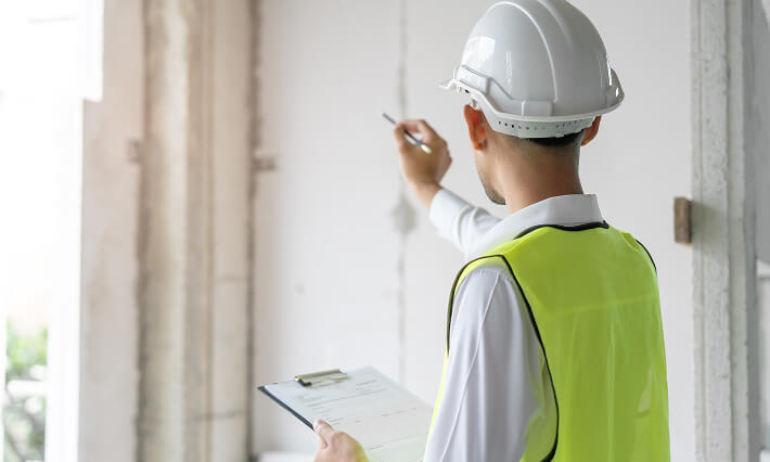 Dallas building inspector recording interior defects on clipboard</p>
<p>