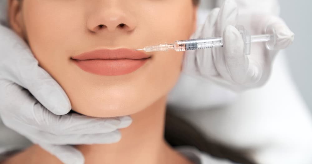 Close-up of a woman receiving a cosmetic facial injection at a clinic.