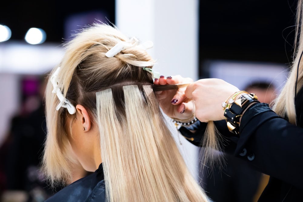 Professional,Hairdresser,Making,Hair,Extensions,For,Blonde,Girl,In,A