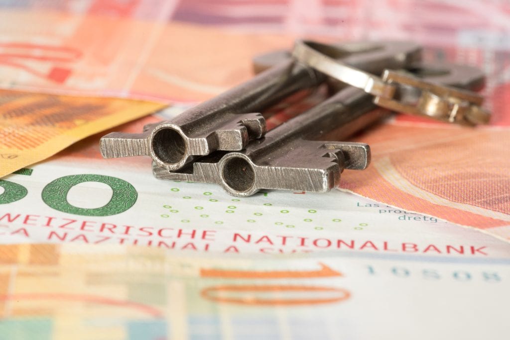 Wohnungssuche in der Schweiz - Schlüssel liegen auf Schweizer Franken