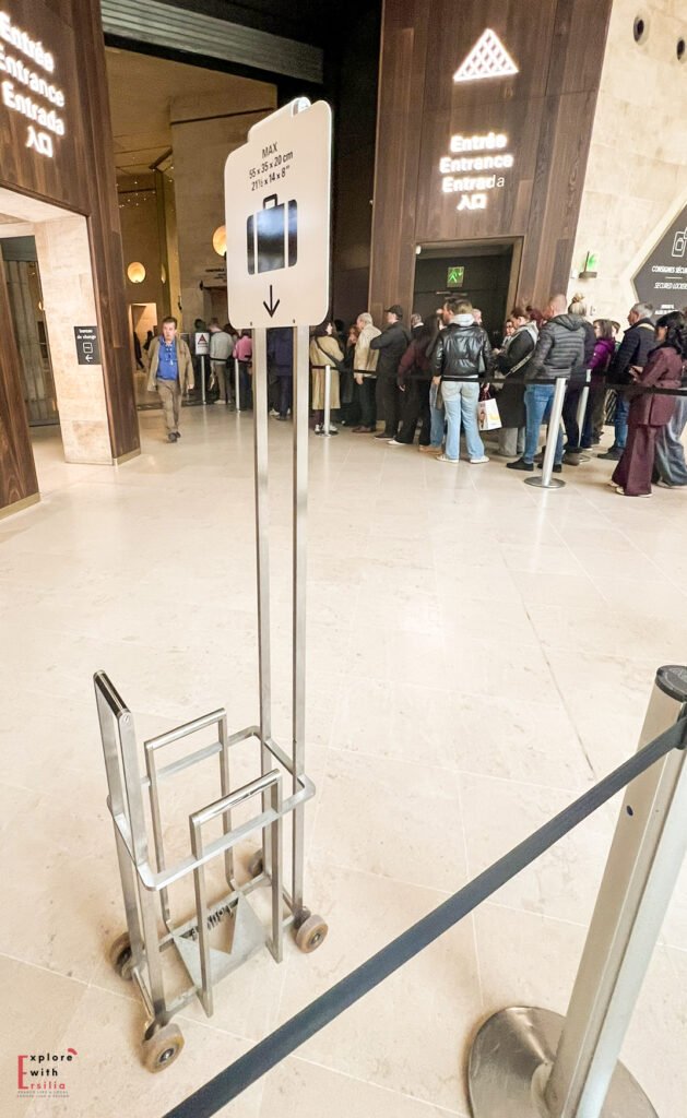 Close-up of the airport-style metal bag sizer used at the Louvre security checkpoint to verify bag dimensions before entry.