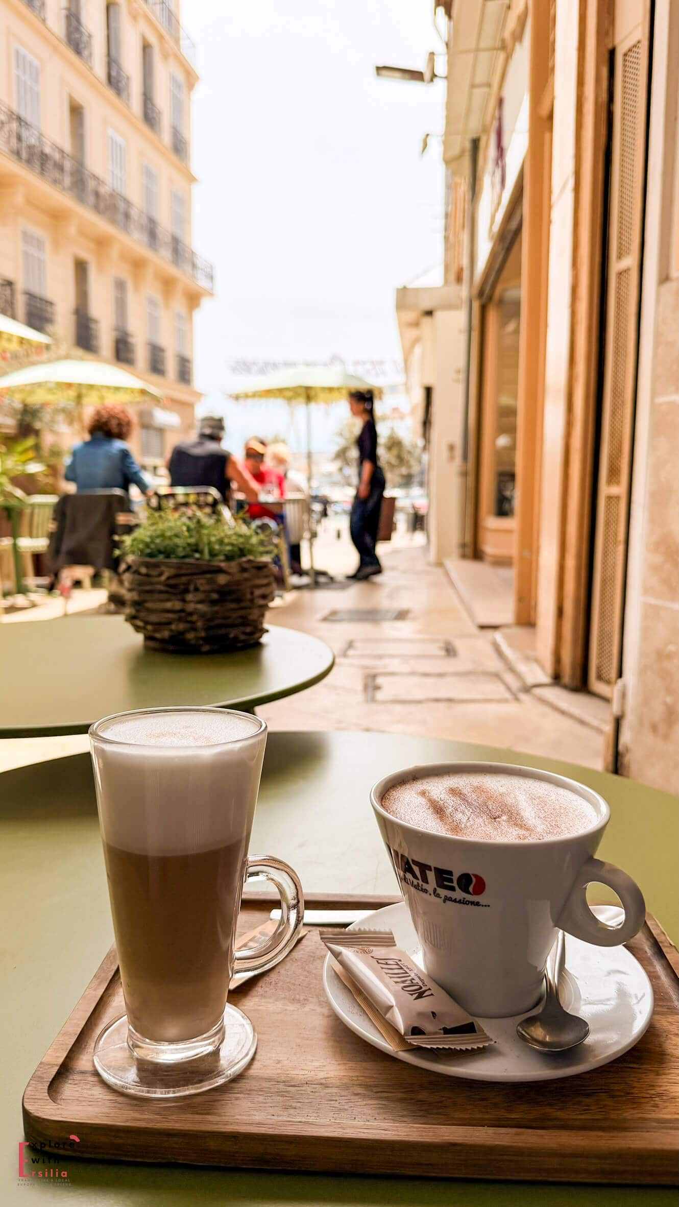 Coffee and latte served on a café terrace table along a quiet street in the historic center of La Ciotat.