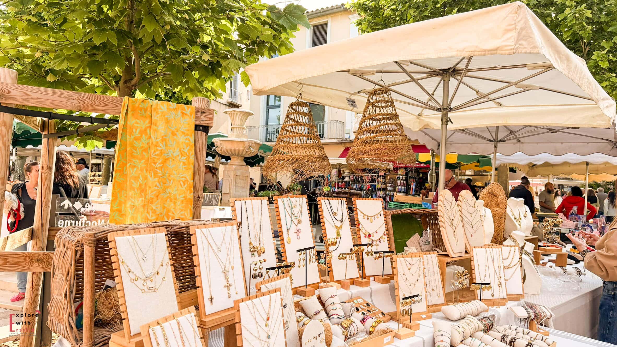 Market stall selling artwork, baskets, and handcrafted goods in the historic center of Cassis.