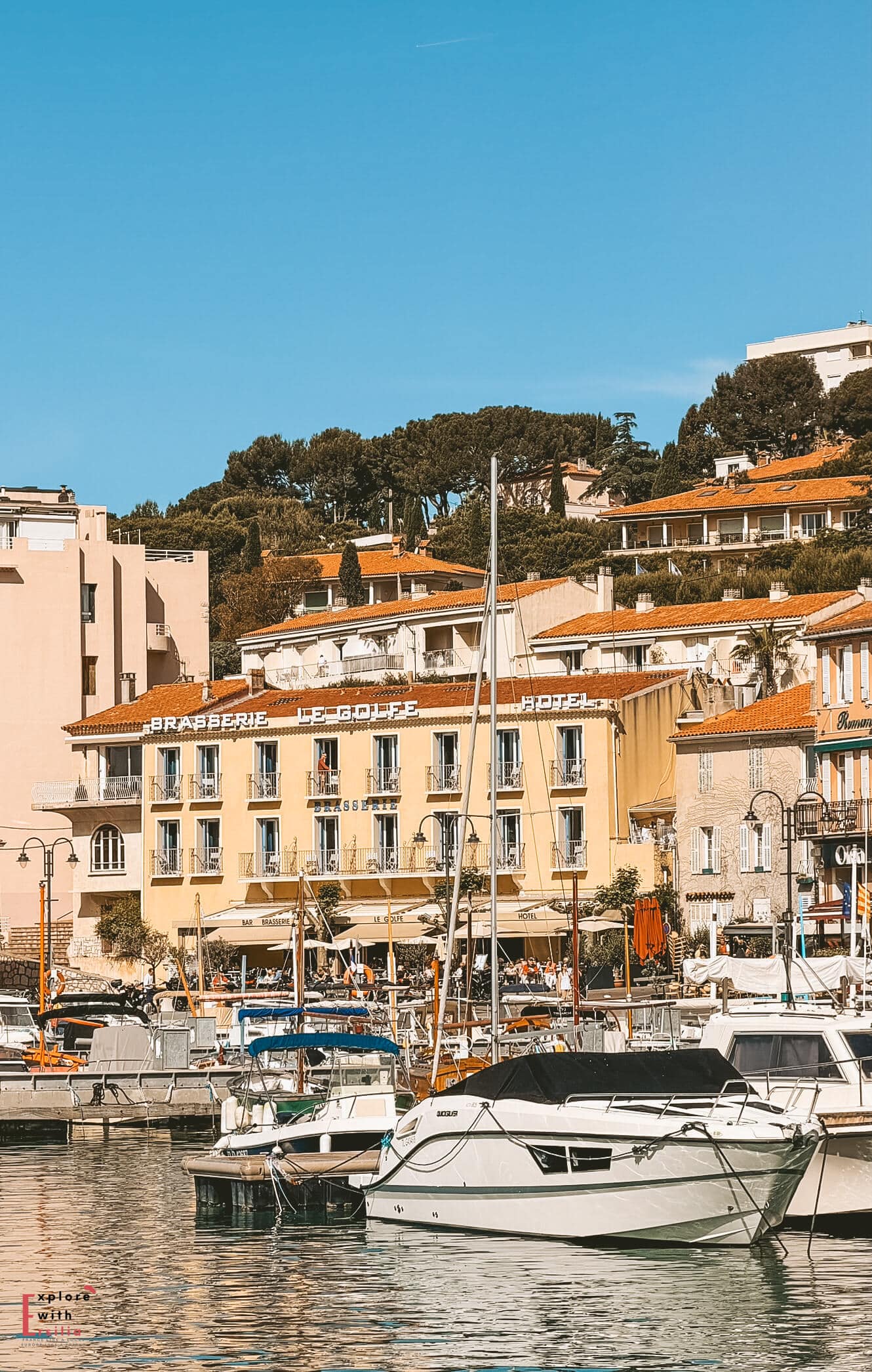 Hôtel Le Golfe overlooking the marina in Cassis with yachts moored in front and hillside buildings rising behind the harbor.