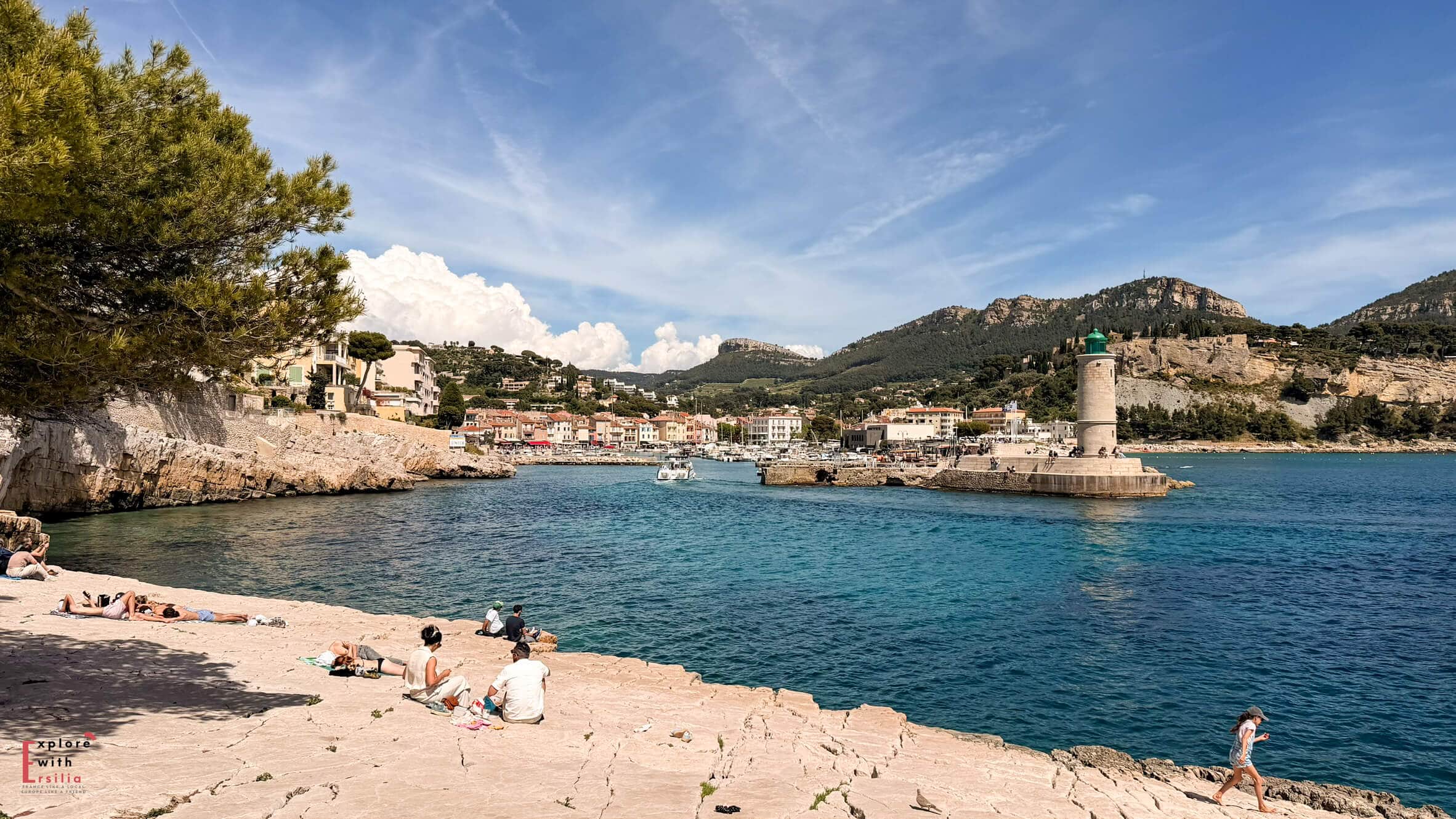 Small beach and sheltered bay in Cassis framed by rocky cliffs and calm blue water.