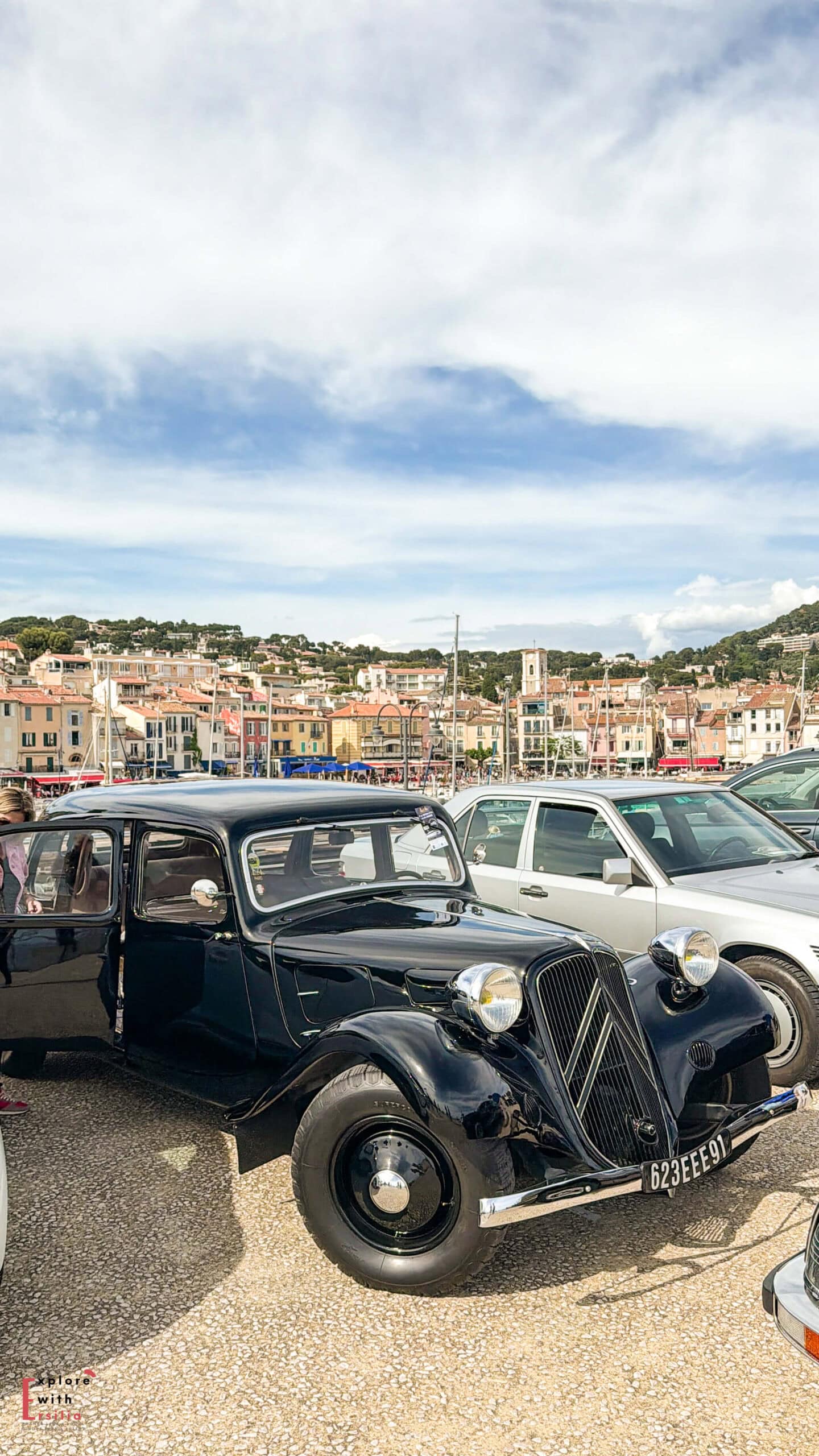 Collection of vintage cars displayed along the Cassis waterfront during a local event beside the harbor.