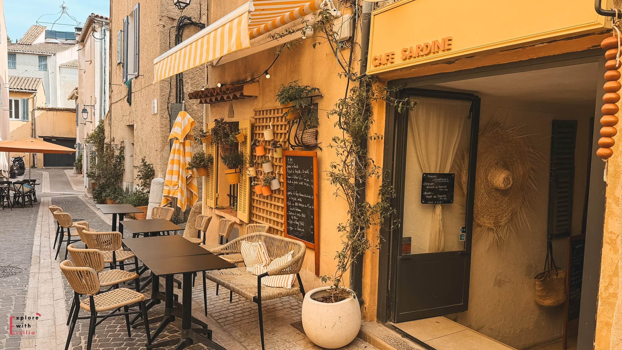 Outdoor terrace at Café Sardine in Cassis with tables set along a quiet street lined with historic buildings.