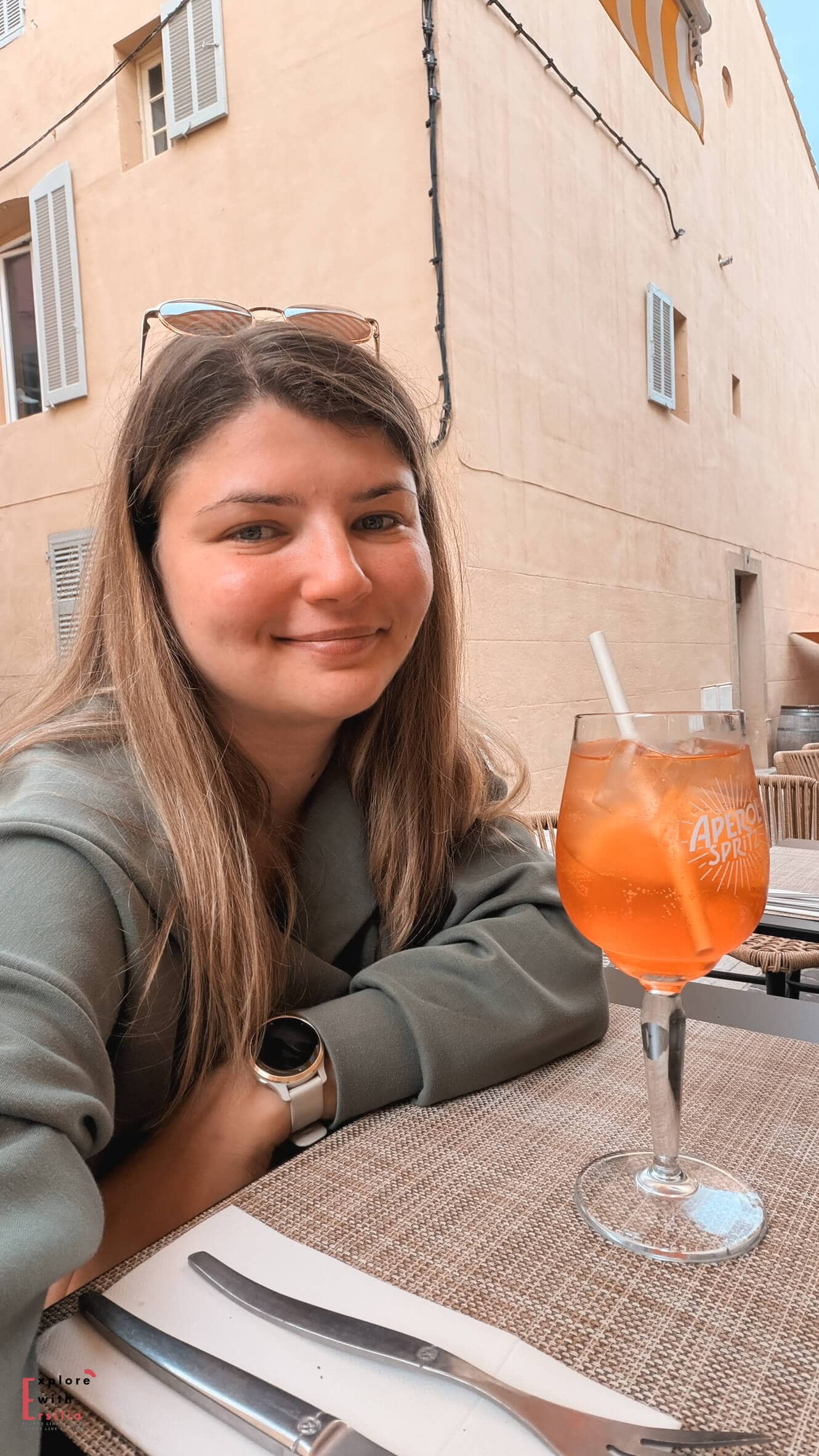 Woman seated at a restaurant table enjoying dinner and drinks in Cassis.