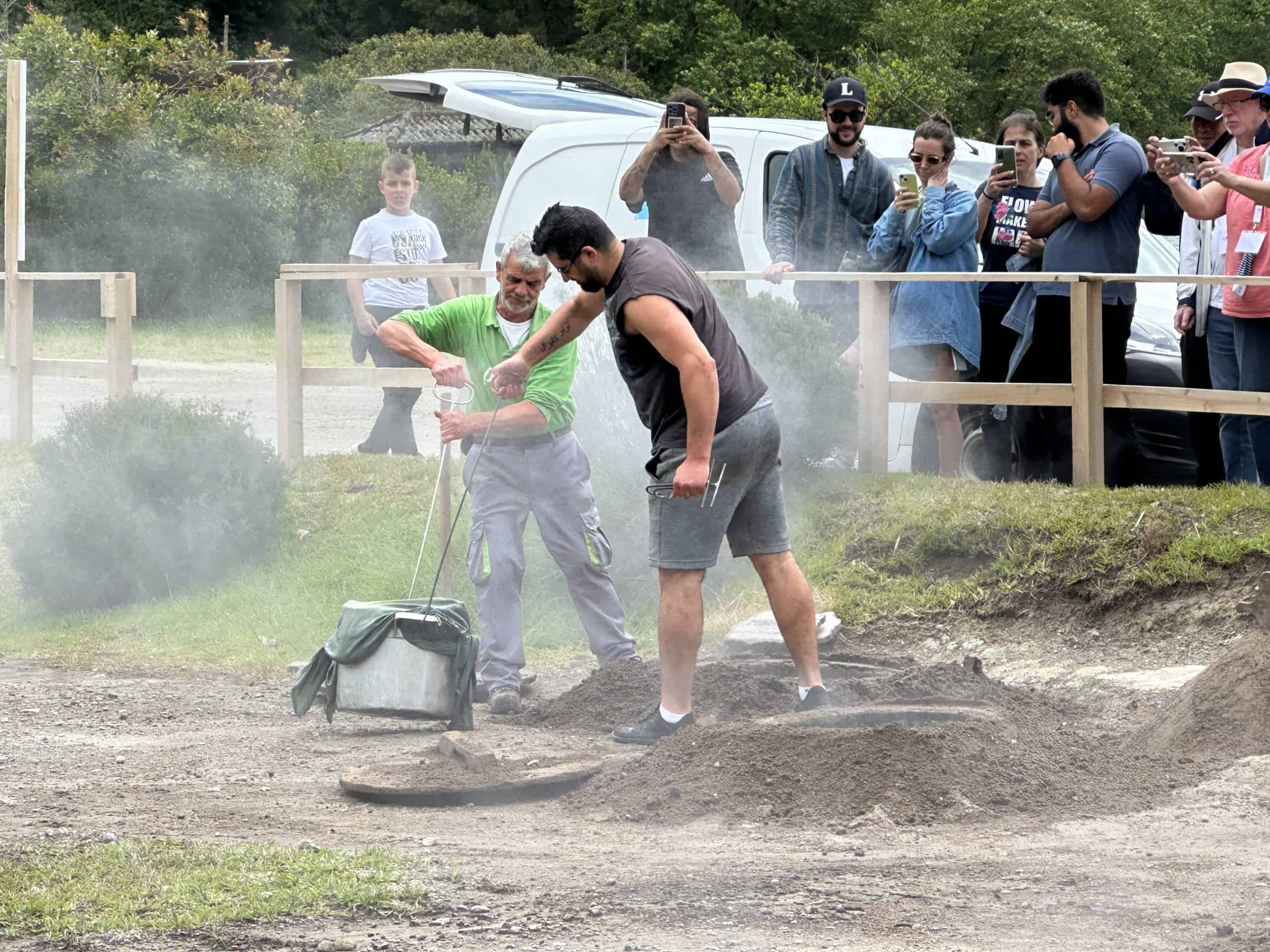 Men removing the pots from the cooking silo