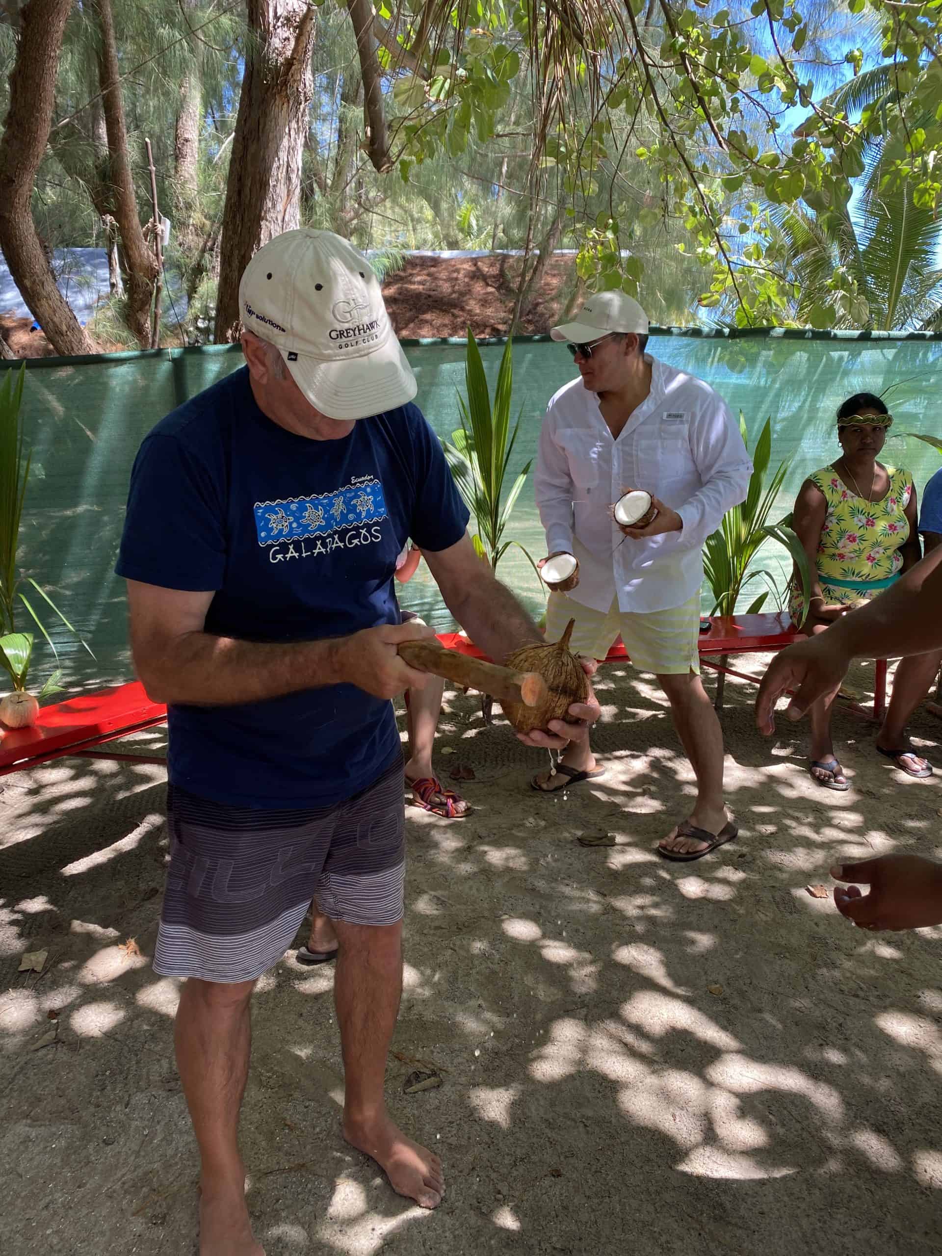 Denis cutting open a coconut