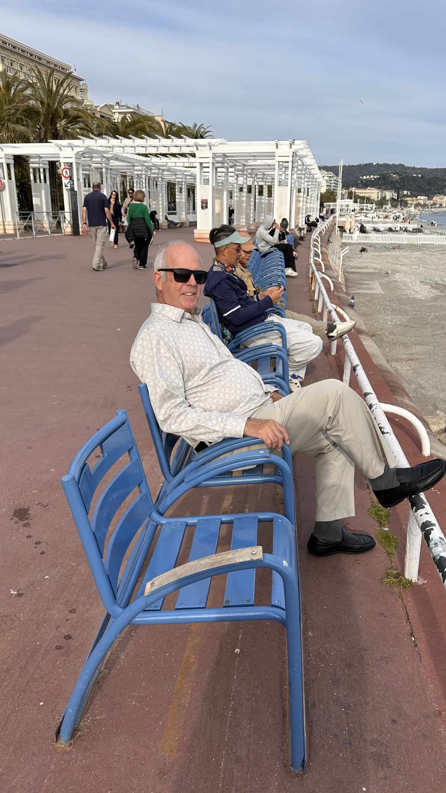 Denis sitting at the beach on the blue chairs