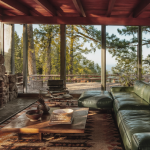Salon maison californienne année 70 avec baies vitrées et cheminée