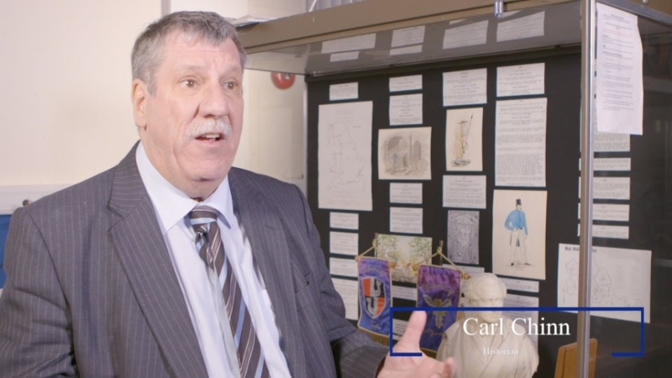 Man in suit speaking in an office environment, film division video production footage.