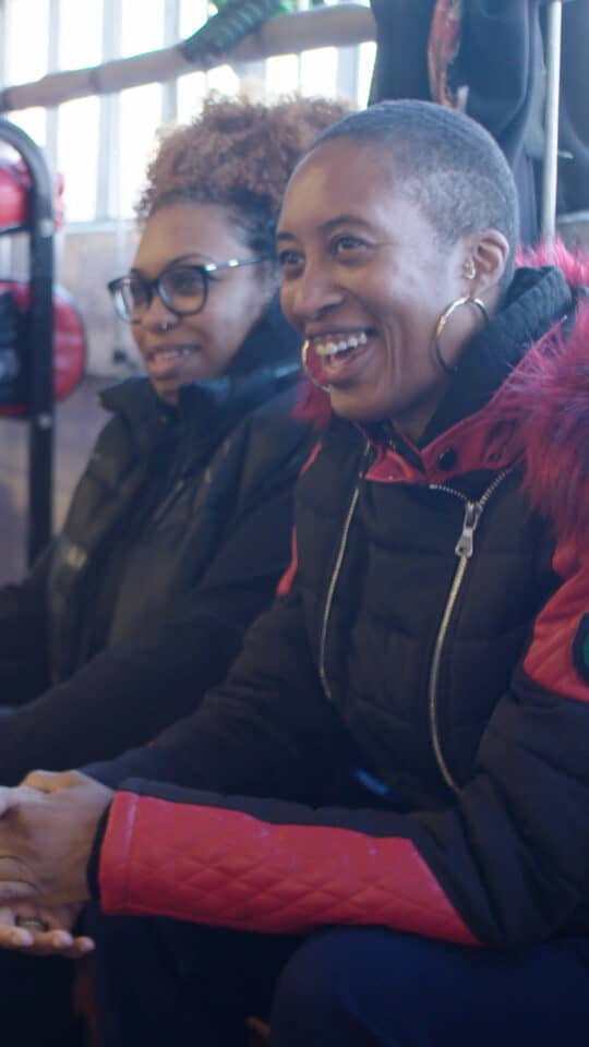 Smile of diverse women in casual wear, showing happiness at a film-related event.