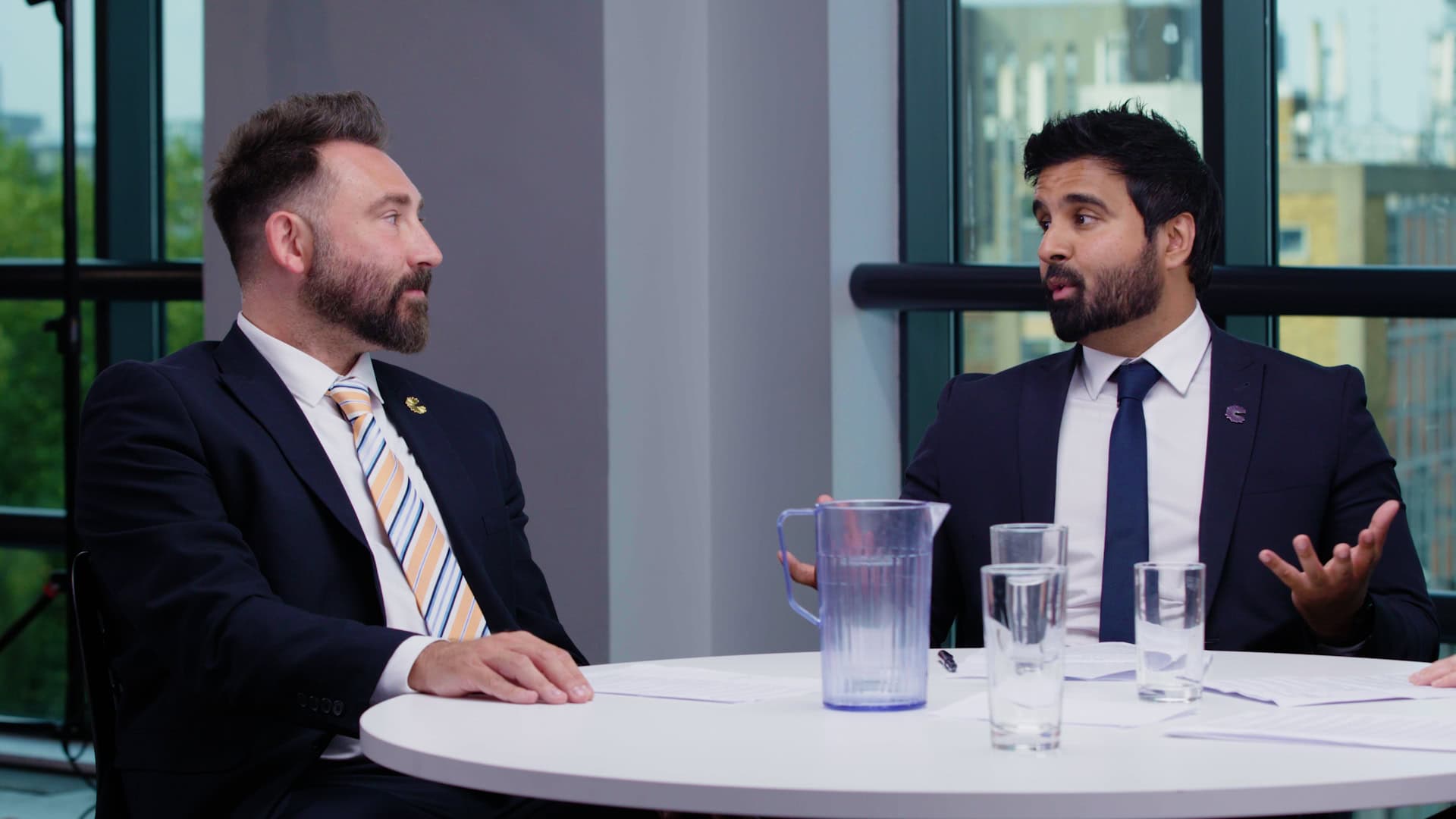 Professional business men discussing at a modern conference table.