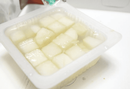 Crispy, sweet and sour pickled radish cubes (Chikin-mu) served in a small bowl as a side for Korean fried chicken.