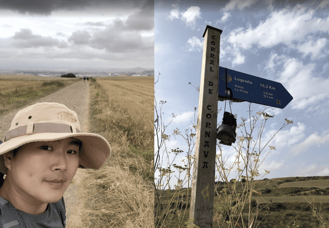 Ben (Sung Kyeong) hiking along the historic Camino de Santiago pilgrimage route, carrying a backpack with the iconic scallop shell attached.