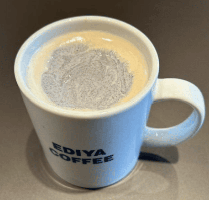 A comforting and warm Black Sesame Latte with creamy foam, served in a ceramic mug.