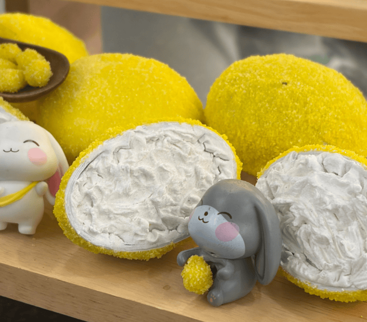A cross-section of a soft rice cake revealing a rich and creamy cheese filling.