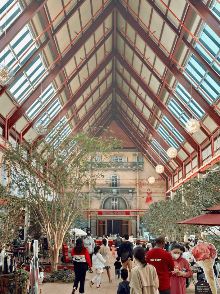 A crowded, open-plan cafe within a repurposed manufacturing building, full of lively energy.