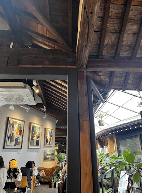 A spacious cafe serving as an art gallery with curated masterpieces on white walls.