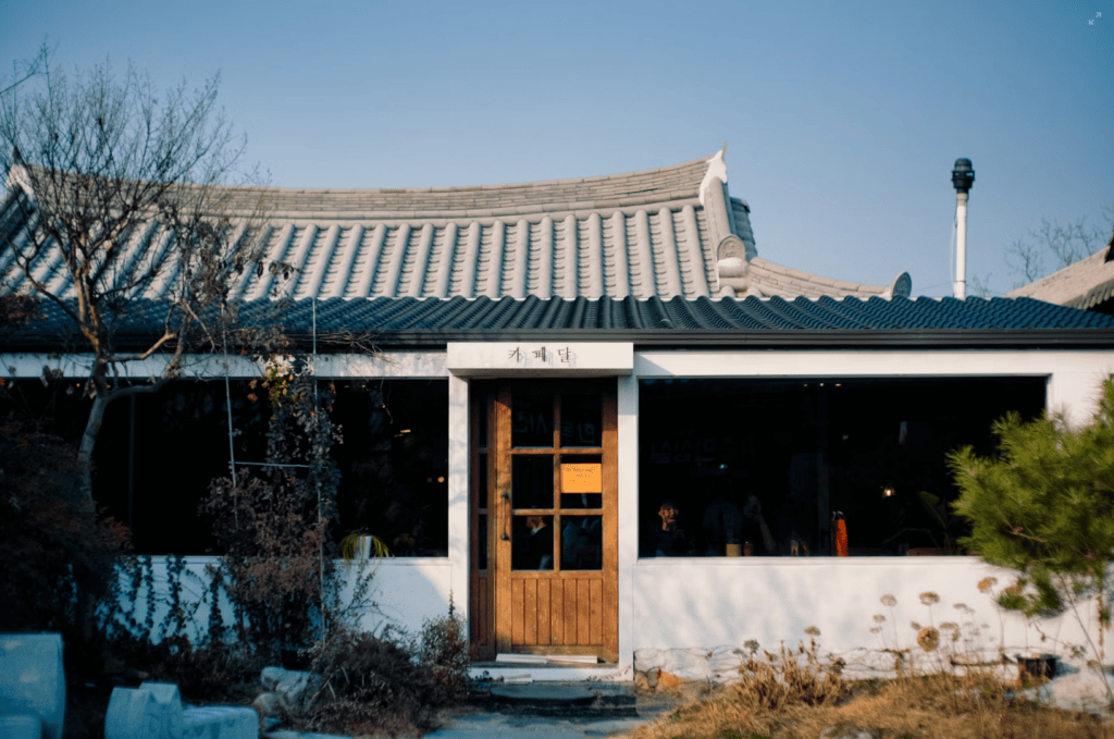Front view of a beautiful, serene traditional Korean Hanok cafe nestled in a quiet garden.
