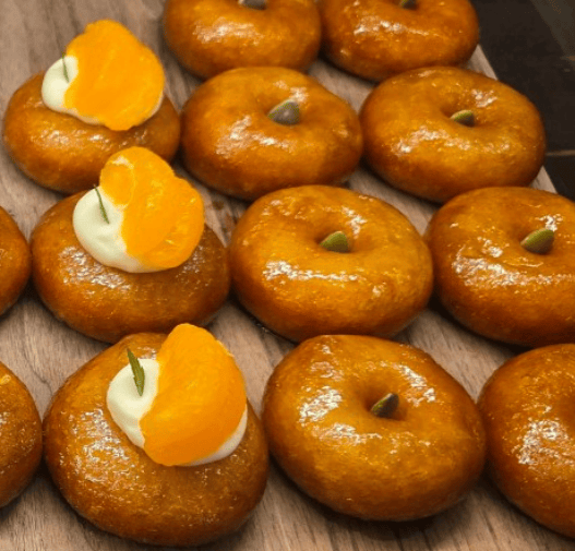 Elegant Gaeseong Juak topped with pumpkin seeds and nuts on a minimalist plate.