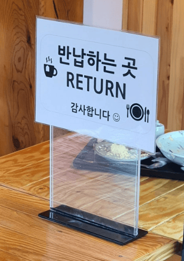 A 'Return' sign in a Korean cafe indicating the designated area for used trays and dishes.
