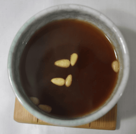 Rich amber-colored traditional Sujeonggwa (cinnamon tea) with distinctive white pine nuts