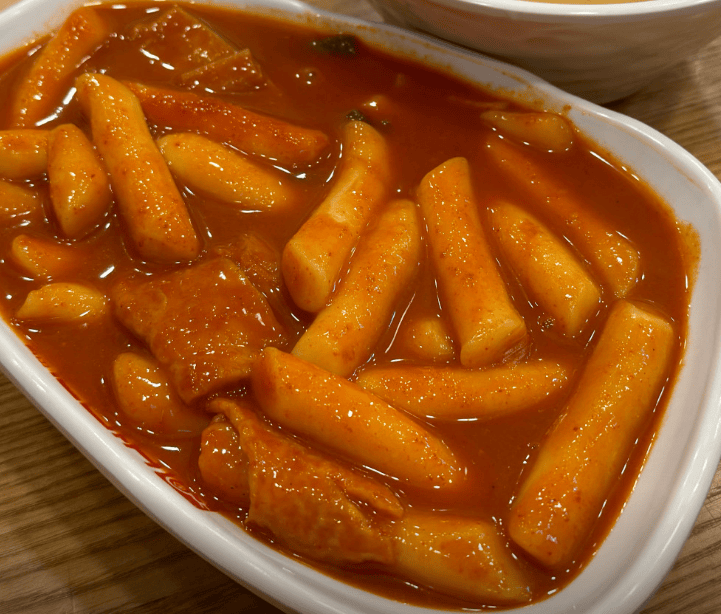 Spicy and chewy Korean rice cakes in a vibrant red chili sauce, a iconic #SeoulFoodie street food.