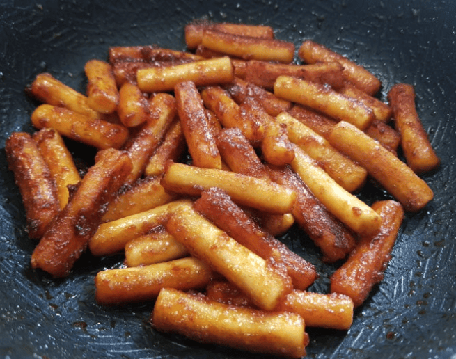 Gireum Tteokbokki (Korean oil-fried rice cakes) tossed in a spicy seasoning and stir-fried until crispy on the outside and chewy on the inside.