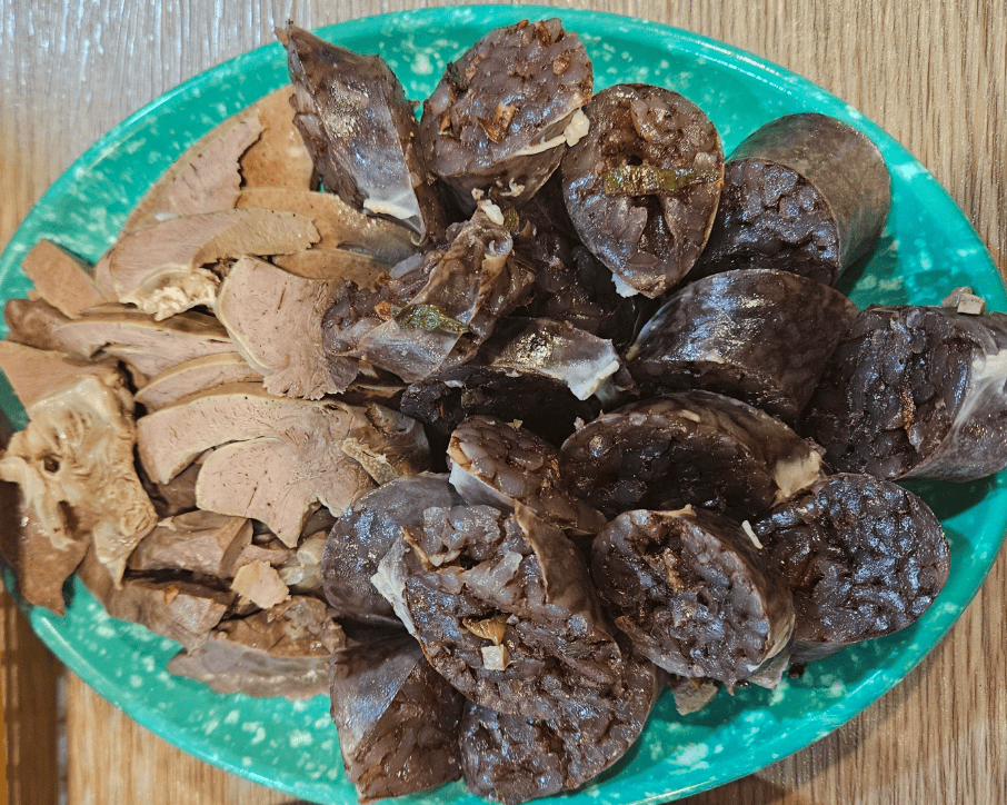 Traditional Korean blood sausage steamed and sliced, served with salt and liver, an authentic local snack.
