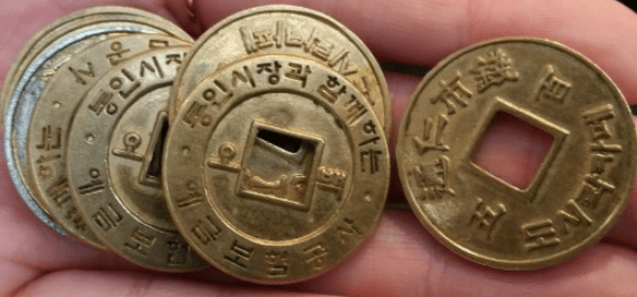 A handful of traditional Korean brass coins, called Yeopjeon, used as currency in the Tongin Market lunchbox cafe.