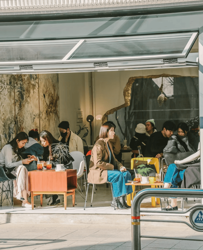 A bustling Seoul cafe filled with people enjoying coffee after lunch, capturing the vibrant #SeoulCafeCulture.