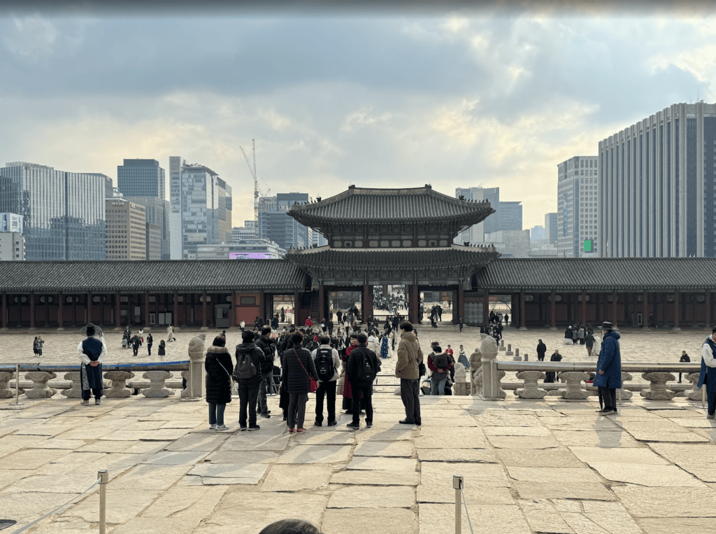 Stunning view of Gwanghwamun Gate in Seoul, showing a perfect harmony between ancient palace and modern city lights.