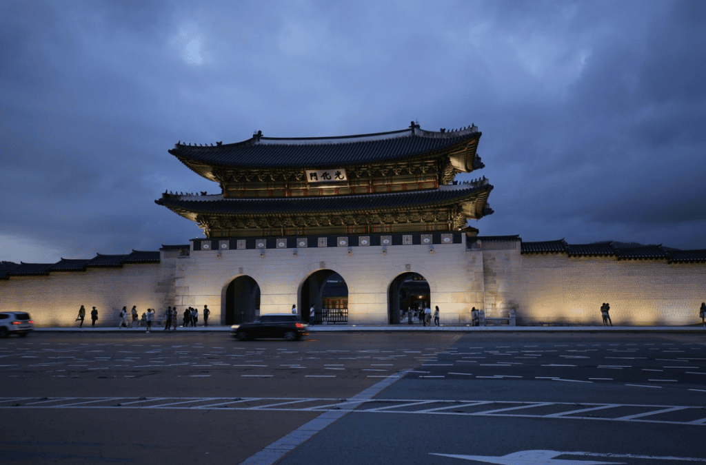 The majestic Gwanghwamun Gate, the main entrance of Gyeongbokgung Palace, illuminated beautifully at night.
