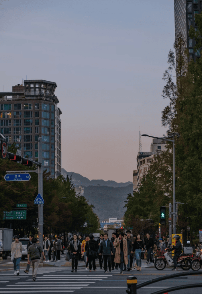 Crowds of people waiting for the green light at a major intersection in Seoul, ready to start their busy day.