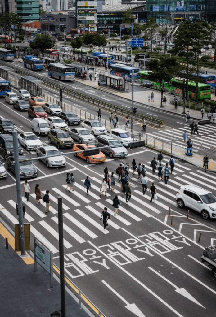 Fast-paced movement of office workers on a crosswalk, highlighting the "Palli-palli" (hurry-hurry) culture of Seoul.
