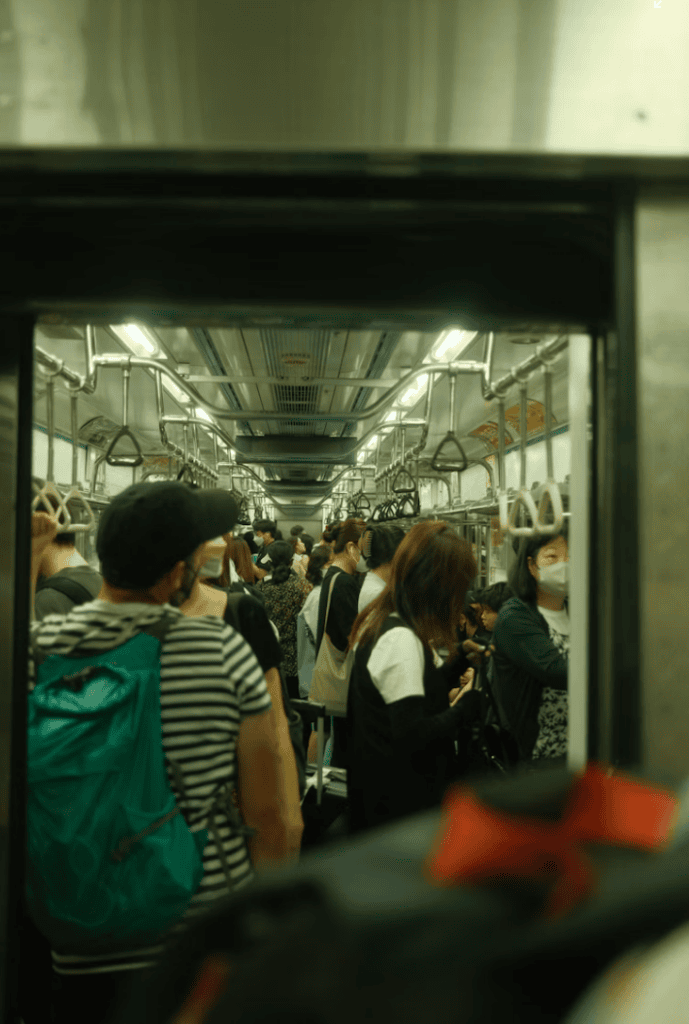 Inside a packed Seoul subway car during peak hours, representing the reality of the city's intense work culture.