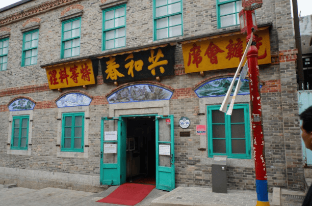 A front view of the Jajangmyeon Museum, a registered cultural heritage site in Korea, showcasing its preserved 100-year-old architecture and traditional Chinese-style wooden doors.